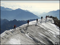 Climbers walk along ridge in Swiss Alps