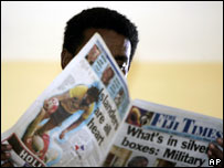 Fijian man reads newspaper 