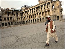 Man waslk past ruined royal palace in Kabul