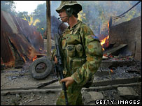 Australian soldier and burning house, Dili, June 2006