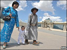 Couple in traditional dress walk through Ulan Bator square